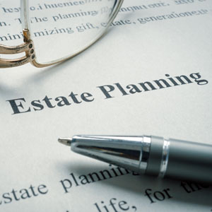 Close-up of 'Estate Planning' document with glasses and a pen, emphasizing its importance.